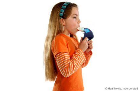 A child breathing out hard into the peak flow meter.