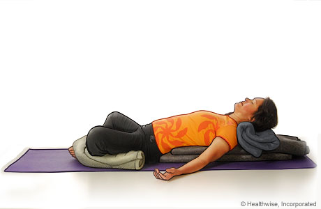 Picture of a woman in step seven of reclining bound angle yoga pose