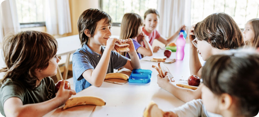 a group of children at a table enjoying healthy food.