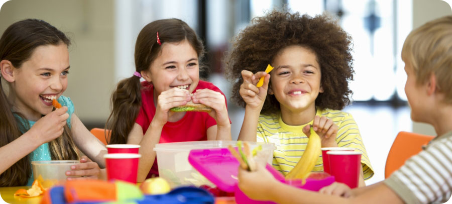 Kids eating a healthy lunch at school.