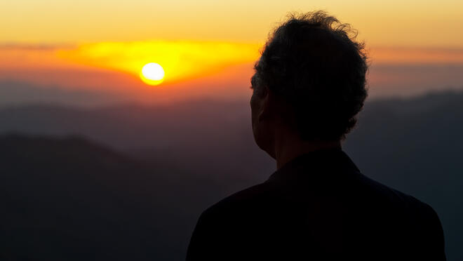 Older adult viewing a sunrise.