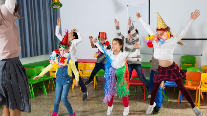 A group of kids celebrate by dancing