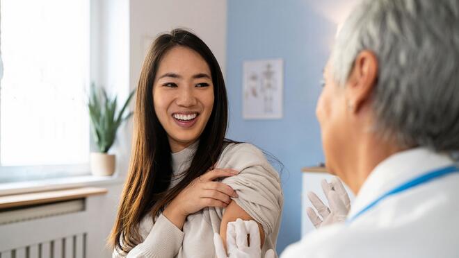 Person smiling after receiving flu shot from health worker