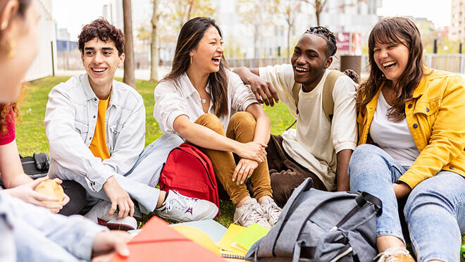 group of teenagers sitting in group laughing