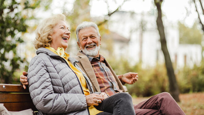 Older adult couple on park bench.