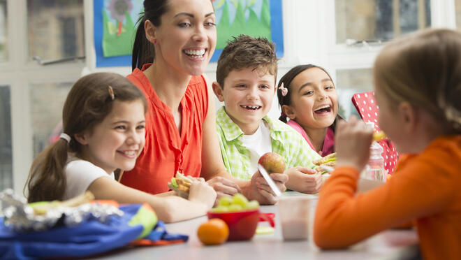 Adult sharing meal with kids.