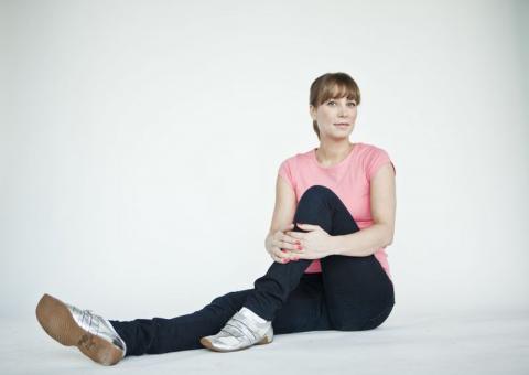 woman sitting on floor stretching