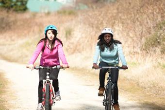 girls riding bicycles on a dirt road
