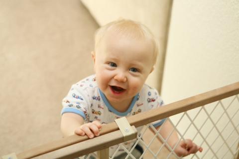 baby holding on to sliding baby gate