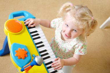toddler playing with toy keyboard and microphone