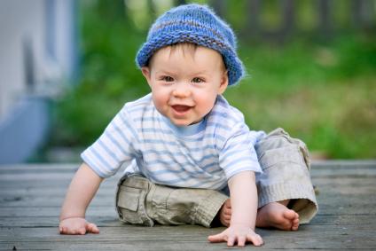 toddler boy with toque playing on deck