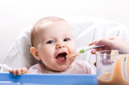 baby eating liquid food from mom's spoon