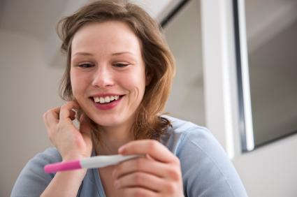 woman looking at pregnancy test results