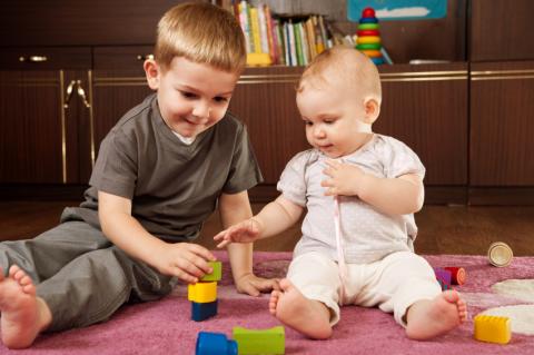 toddler and baby playing with blocks