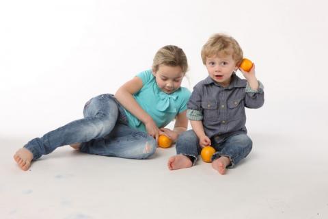 toddler and older girl playing with oranges