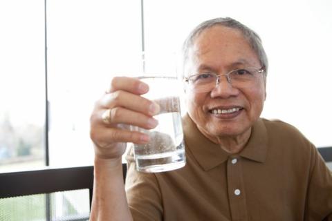 senior man holding glass of water
