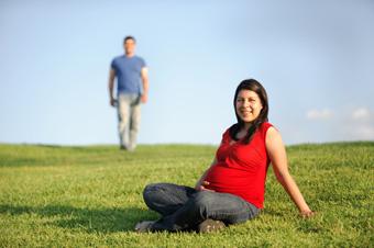 pregnant woman and man in field outdoors