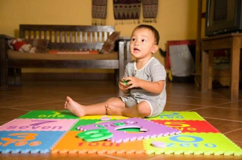 baby 9-12 months playing on floor with foam play mats