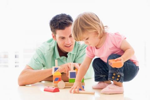 Dad and toddler play with blocks and toys