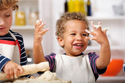toddlers making dough and using rolling pin