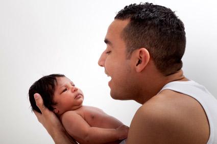 father holding and talking to baby