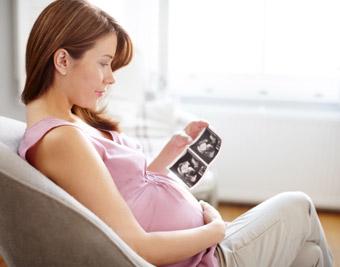 pregnant woman in chair looking at ultrasound results