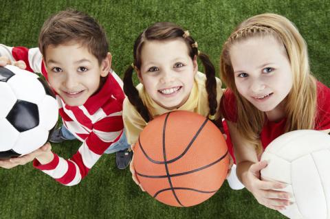 boy and girls with basketball, soccer ball and volleyball