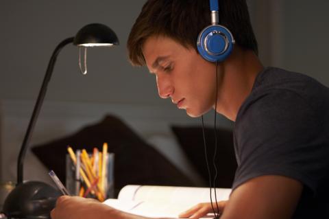 teen boy reading alone with headphones on