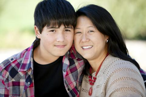 teen boy with with arm around his Mom