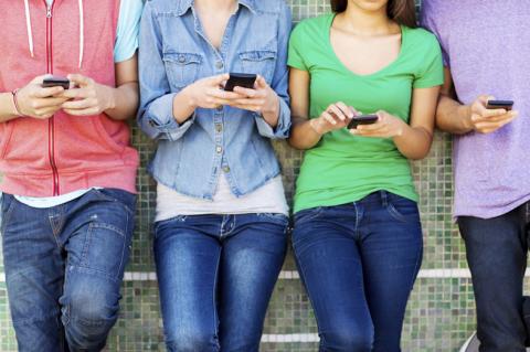teens with phones in hands texting and using social media