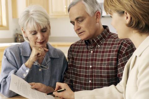 older adult couple reviewing document with advisor